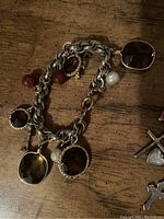Bracelet with textured chunky silver-tone chain and large square and round amber-colored faceted stones, with white faux pearl charm.