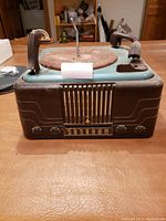 Front view of Emerson Model 579A record player and radio unit showing speaker grille, tuning dial, and control knobs.