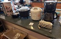 Countertop showing the coffee maker, rice cooker, deep fryer, hand mixer, blender box and waffle iron