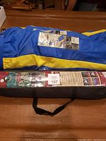 Photo of two blue and yellow multi-position lounger chairs in carrying cases and a black carrying bag for a dome tent