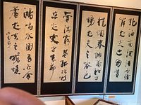 Front side of the 4-panel folding screen showing Chinese calligraphy panels with artist seal.
