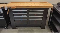 Full front view of Craftsman workbench showing steel frame, wood top, drawers and vise