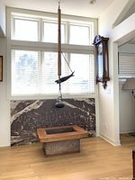 Bamboo and iron Jizai Kagi hearth kettle hook with wooden fish lever and hanging chain above wooden hibachi