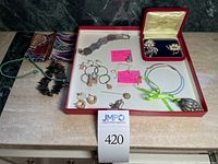 Full lot view showing bracelets, brooches in box, pendants including Disney Mickey charm, and large hoop earrings