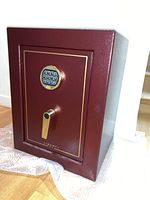 Front view of burgundy Liberty fire safe with gold-trimmed door, digital keypad lock and lever handle