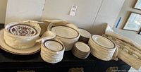 Multiple stacks of plates and cups in padded carriers on table