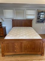 Front view of Simply Amish McCoy queen bed frame assembled with mattress in bedroom