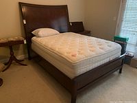 Full view of bed with mattress and pillow in bedroom setting