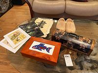 Overview of the table showing all items including wooden boxes, wooden shoes, paintings, photograph, and calligraphy notes.