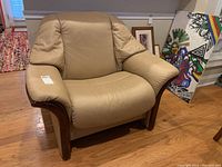 Front view of full recliner chair showing tan leather and wood frame