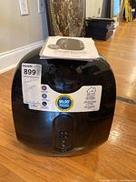 Front view of black Homedics ultrasonic humidifier with stickers describing features and a tag with lot number.