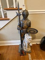 Full view of knight statue, lion base, and two small figurines at base