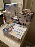 Multiple boxed health and personal care devices including MyPurMist steam inhalers, Naväge nasal irrigator, Conair and Resperate devices, with sterile water supplies