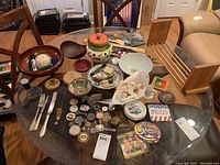 Overview of assorted tableware and decorative items on glass table