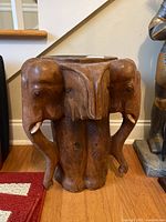 Front angle showing two elephant heads and the side table top.