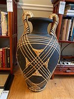 Full front view of the large black ceramic vase with natural straw details and handles, showing overall design and condition.