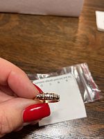 Side view of ring held between fingers showing band and diamond row