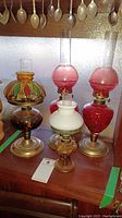 Group shot of four glass oil lamps on wooden surface