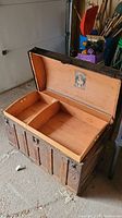 Open trunk showing the insert compartments and interior decoration on lid.