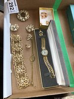 Full lot view in box showing watch, earrings, brooches, and bracelets.