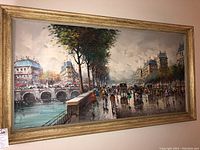 Full frontal view of the framed canvas painting showing Paris street and bridge scene