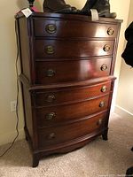 Front view of vintage Sheridan style Huntley dresser showing curved front and six drawers with brass drawer pulls.