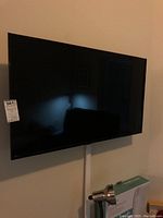 Samsung flat screen TV mounted on wall with power cable and clean bezel visible.