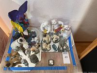 Top view showing various animal figurines including colorful painted dogs, polar bears, and musical bears on mirrored bases.