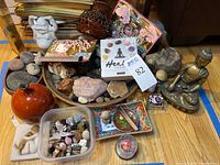 Full lot view showing Thai brass Buddha statue, assortment of stones, inspirational stones box, assorted figurines and decorative objects on wood floor.