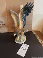 Front view of ceramic eagle figurine showing detailed paint and posture.