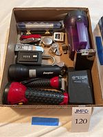 Photo of all items in cardboard box, including flashlights, pocket watch, mini tool kit, and other small tools