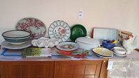 Full display of all serving dishes, bowls, and figurines arranged on a wooden sideboard