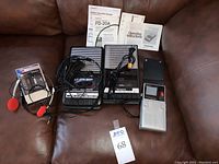 Two Panasonic slim line portable cassette player recorders with manuals, Bell & Howell corded microphone, power cord, Sony Walkman with headphones and 49er branded Sony Watchman