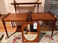 Group view of two side tables, mirror leaning front, shelf mounted behind