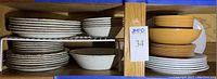 Shelf with stacked plates and bowls of Texas Ware floral and Marigold sets