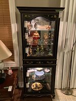 Full front view showing upper and lower glass display sections with lighting on and contents inside.