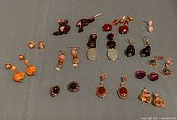 Overhead shot of all 12 pairs of earrings on blue cloth