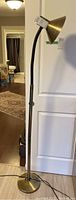 Full view of 68 inch floor lamp with flexible neck, conical brass-colored shade, and metal base without weighted base.