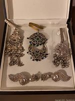 Photo of full set of garment tassels and clip-on earrings in a white-lined box