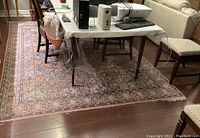 Full view of rug under table showing overall pattern and size relative to furniture