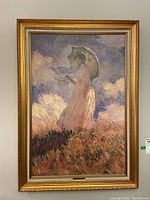Full view of the framed Monet print showing the woman with a parasol in a field.