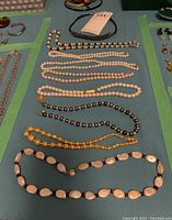 All eight necklaces arranged on table
