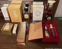 Nine perfume items including partial and boxed bottles from Chanel, Chloe, Guerlain, Perry Ellis, Jardanel, Sugandhco in various packaging and sizes.