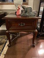 Front view of solid cherry side table with drawer and brass handle, showing marks on top surface.