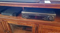 Sony SLV685HF VHS player and slim Sony DVD player on cabinet.