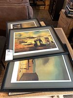 Five framed Salvador Dali prints stacked and laid on a surface, showing the style and framing of the set