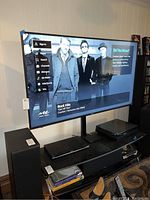 Front view of powered-on TV showing Roku menu and Rock Hits channel