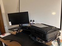 Overview photo showing all items on a table: HP monitor, laptop bag, dust spray cans, and computer speakers.