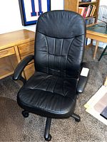 Front view of the black high back office chair showing padded seat and backrest with stitching details, armrests, and caster wheel base.