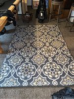 Full view of the area rug showing the pattern, colors, and size in the room context with pool table and bar stools nearby.